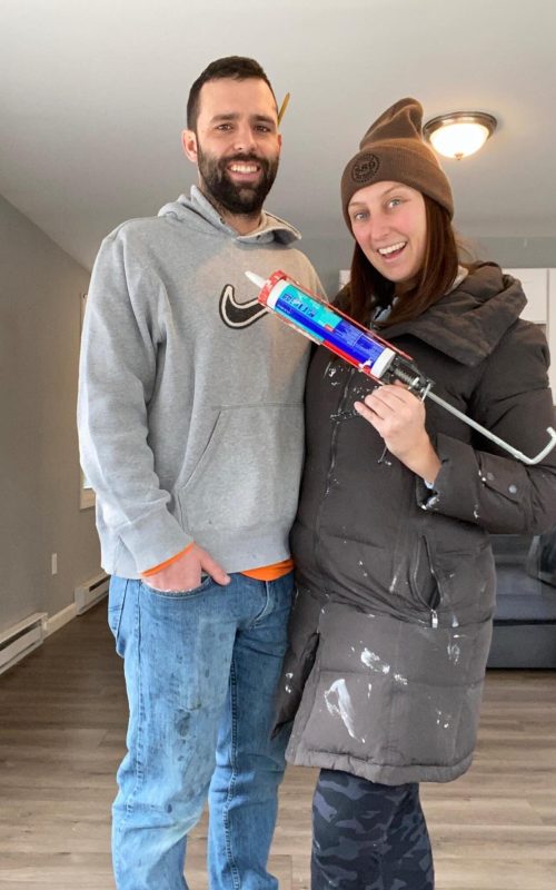 man and woman standing together. woman is holding a caulking gun.